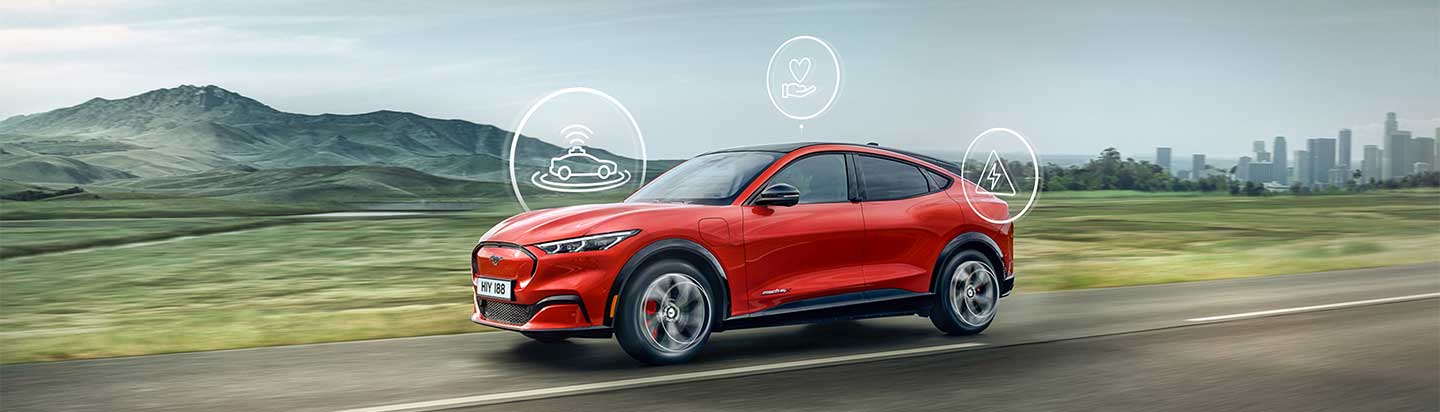 Ein rotes Elektroauto fährt auf einer Straße, umgeben von Bergen und Stadtansicht, mit Symbolen für technologische Funktionen.